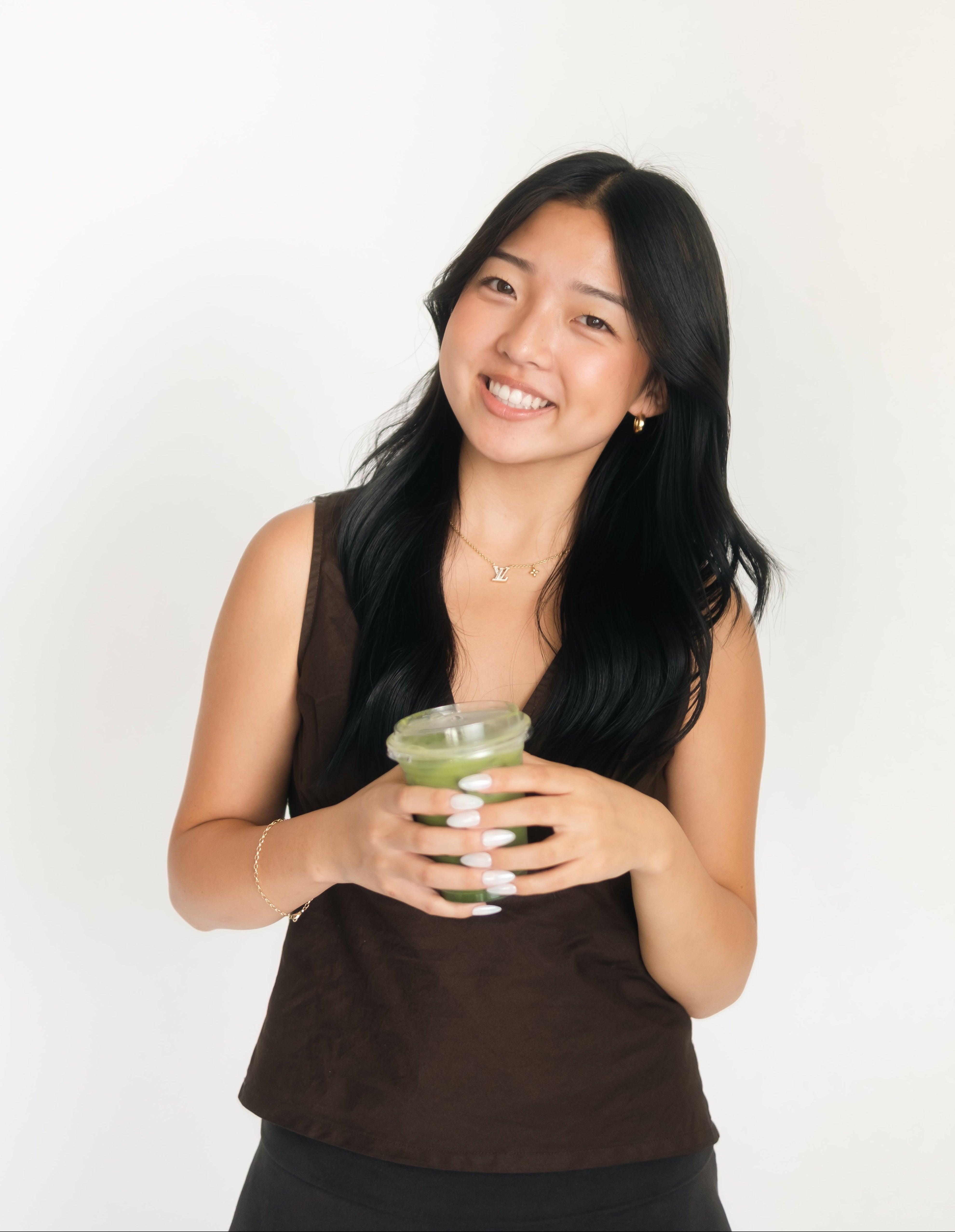 Woman holding a green drink against a white background